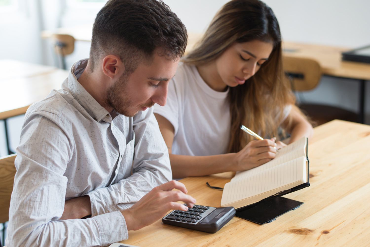 Deux étudiants concentrés en révision de maths chez occi fomation dans le tarn, calculatrice et carnet ouverts sur la table