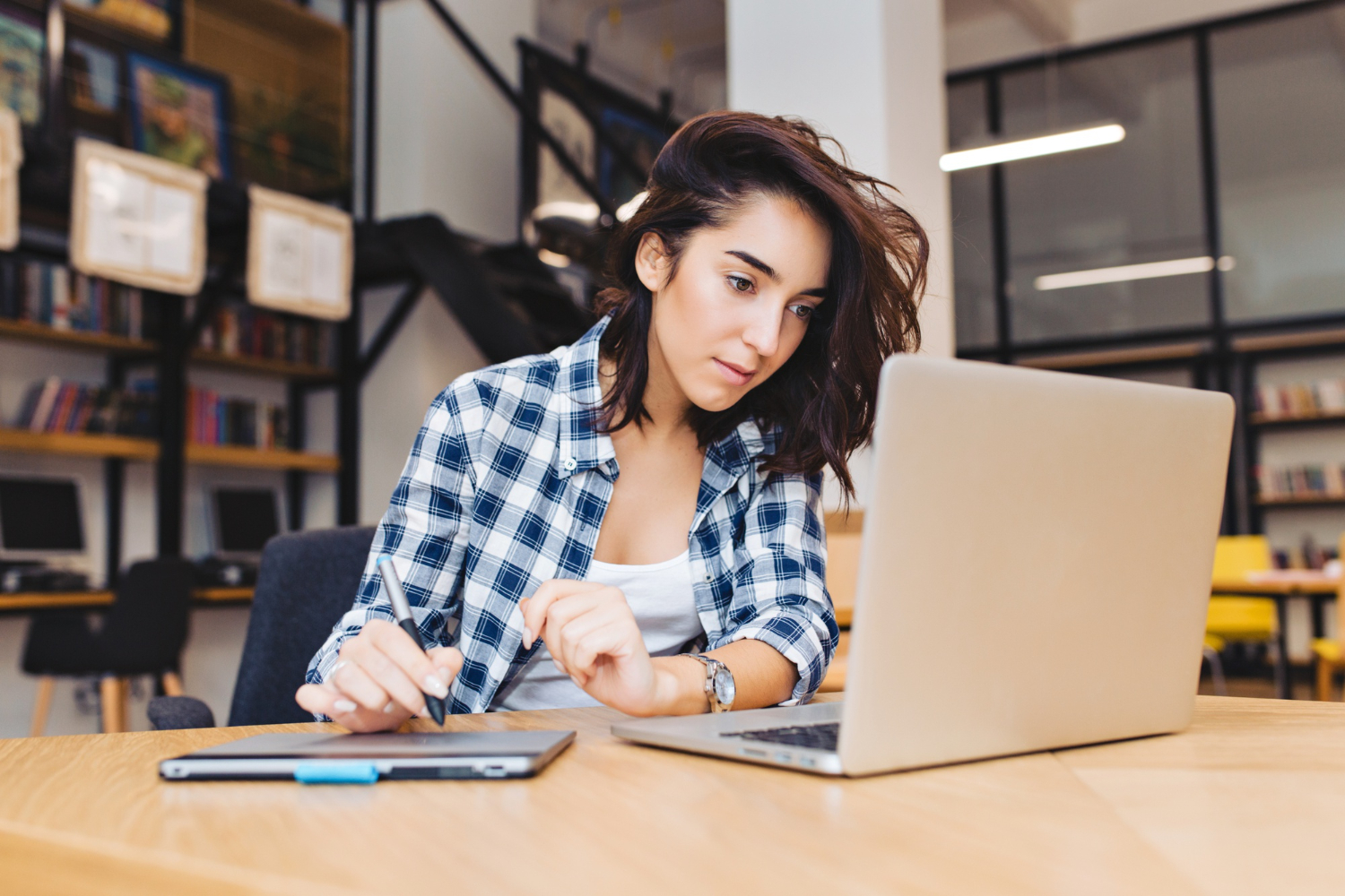 Apprenante concentrée sur tablette graphique chez occi fomation dans un espace de coworking moderne tarn