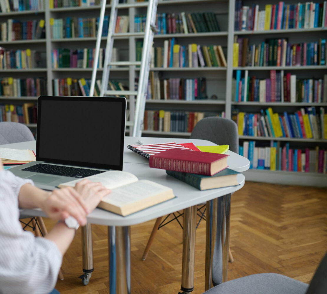 Espace d’étude en bibliothèque avec livres et ordinateur pour formation occi fomation dans le tarn